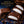 Four Fry chocolate fondant pieces arranged on a dark blue surface with chocolate curls. Two pieces are cut open to show a white cream or caramel-like center.