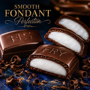 Four Fry chocolate fondant pieces arranged on a dark blue surface with chocolate curls. Two pieces are cut open to show a white cream or caramel-like center.