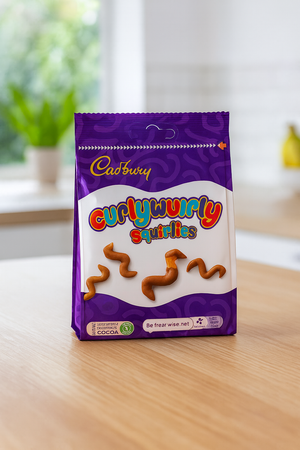 Cadbury Curly Wurly Squirrels packaging on a wooden surface with a blurred background