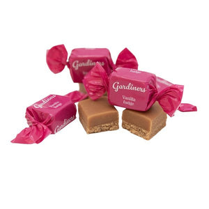 Four Gardiners vanilla truffles, some unwrapped to show the smooth caramel-brown center and crumbly biscuit base, with three wrapped in bright magenta paper and tied with matching bows, on a white background.