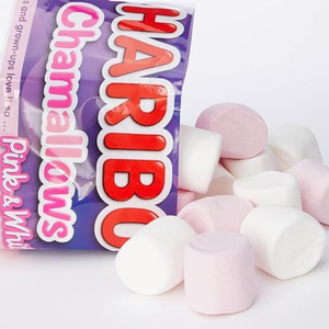 A bag of Haribo Chamallows pink and white marshmallows with several pink and white marshmallows spilled out on a white background.