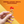 Hand holding a chocolate with red top and gold wrapper against an orange background, featuring text about luxury and indulgence.