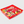 A red plastic divided candy tray filled with assorted gummy candies, shown on a light gray background.