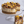 Layered dessert with chocolate and peanut butter chunks on a glass cake stand.