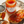 Jar of apricot jam with a spoonful on a piece of bread, on a decorative plate.