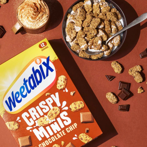 Weetabix Crispy Minis Chocolate Chip cereal box with a bowl of cereal and chocolate pieces on a brown background
